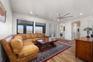 Living room with ceiling fan, light wood-type flooring, and recessed lighting