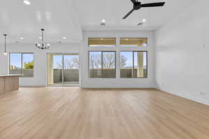 Unfurnished living room with a ceiling fan, light wood-style flooring, and suspended lighting
