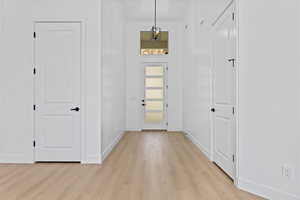 Foyer with baseboards and light wood-style flooring