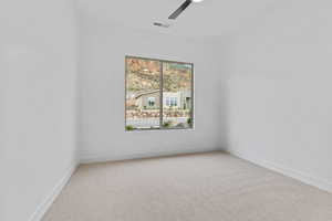 Unfurnished room featuring light carpet and ceiling fan