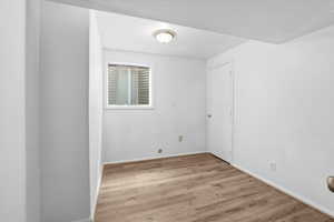 Spare room featuring light wood-type flooring and baseboards