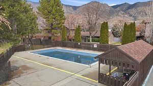 View of pool featuring a mountain view, a fenced backyard, and patio surround