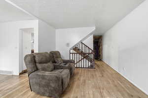 Sitting room featuring light wood-style flooring and a textured ceiling