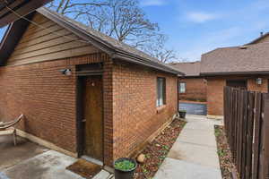 View of property exterior featuring brick siding and roof with shingles