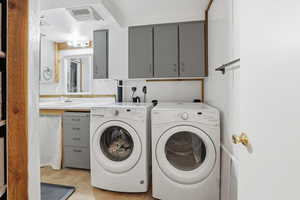 Laundry room with separate washer and dryer and cabinet space