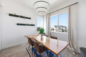 Dining room featuring light wood-type flooring and suspended lighting