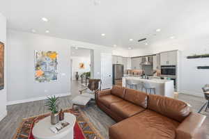 Living room with light wood finished floors and recessed lighting
