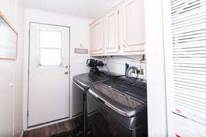 Laundry area featuring cabinet space, wood finished floors, independent washer and dryer, a heating unit, and crown molding