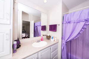 Full bath featuring ensuite bath, vanity, and a shower with curtain