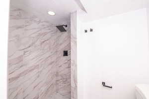 Full bath featuring a stall shower and a textured ceiling