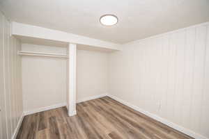 Unfurnished bedroom with wood finished floors, a textured ceiling, and a closet