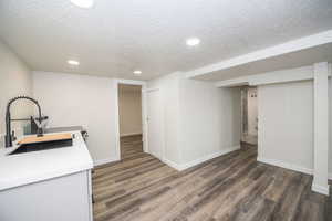 Kitchen featuring a textured ceiling, dark wood-type flooring, recessed lighting, and white cabinets