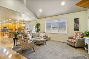 Living room with recessed lighting, vaulted ceiling, and light wood-type flooring