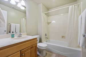 Full bath featuring vanity, shower / bathtub combination with curtain, and light tile patterned floors