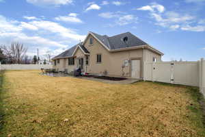 Rear view of house featuring a gate, a fenced backyard, stucco siding, and a patio area