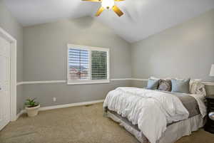 Bedroom featuring vaulted ceiling, carpet flooring and ceiling fan