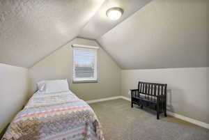Bedroom with light carpet and a textured ceiling