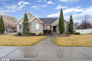 View of front facade featuring stone siding, a gate, and stucco siding