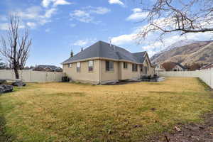 Rear view of house featuring a fenced backyard, a patio, a gate, and roof with shingles