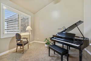 Sitting room featuring light colored carpet and vaulted ceiling