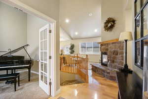 Staircase with a stone fireplace, recessed lighting, and wood finished floors