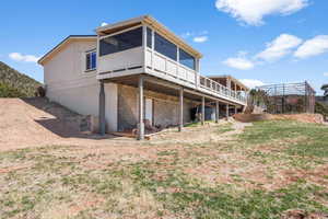Back of property featuring a wooden deck and a sunroom