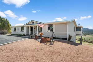 Ranch-style house with a metal roof and covered porch