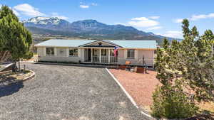 View of front of house with a porch, a mountain view, and a metal roof
