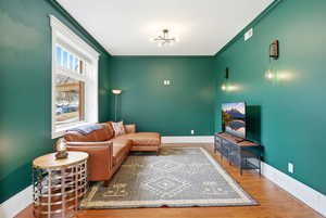 Living area with wood finished floors and crown molding