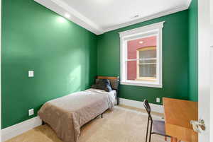 Carpeted bedroom featuring baseboards and crown molding