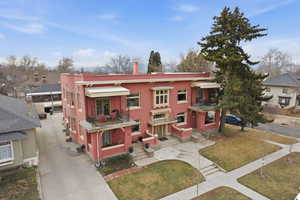 View of front of property featuring a front lawn, a balcony, and driveway
