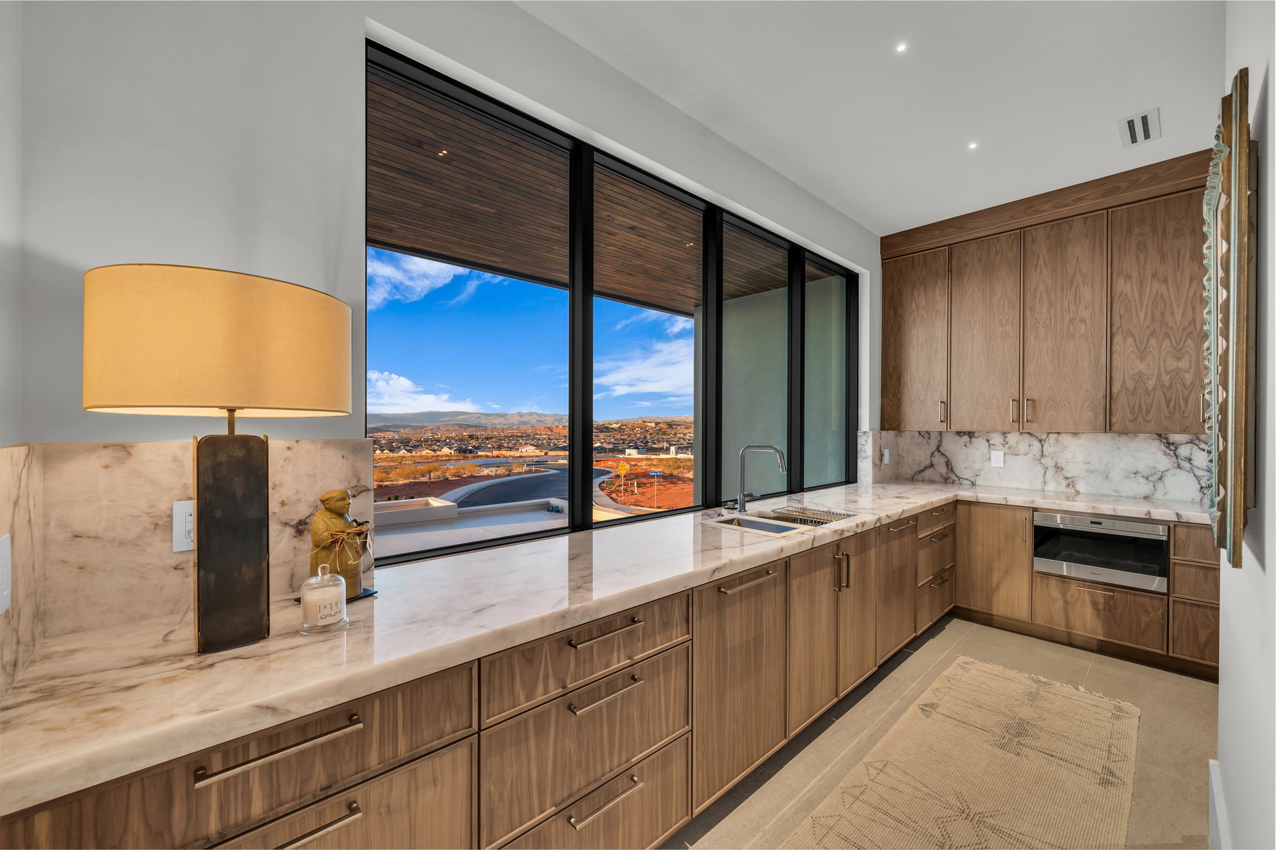 Kitchen with light stone countertops, decorative backsplash, modern cabinets, wood finish cabinetry, and recessed lighting