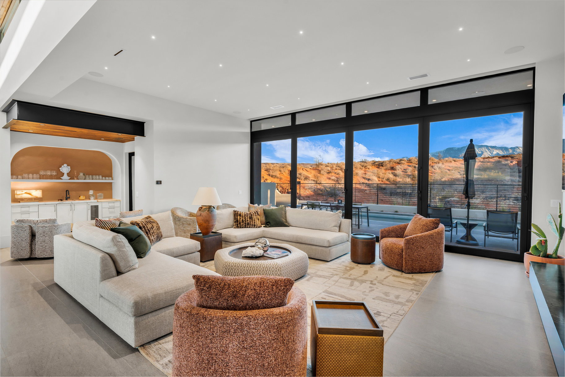 Living room with floor to ceiling windows, a mountain view, bar with sink, and recessed lighting