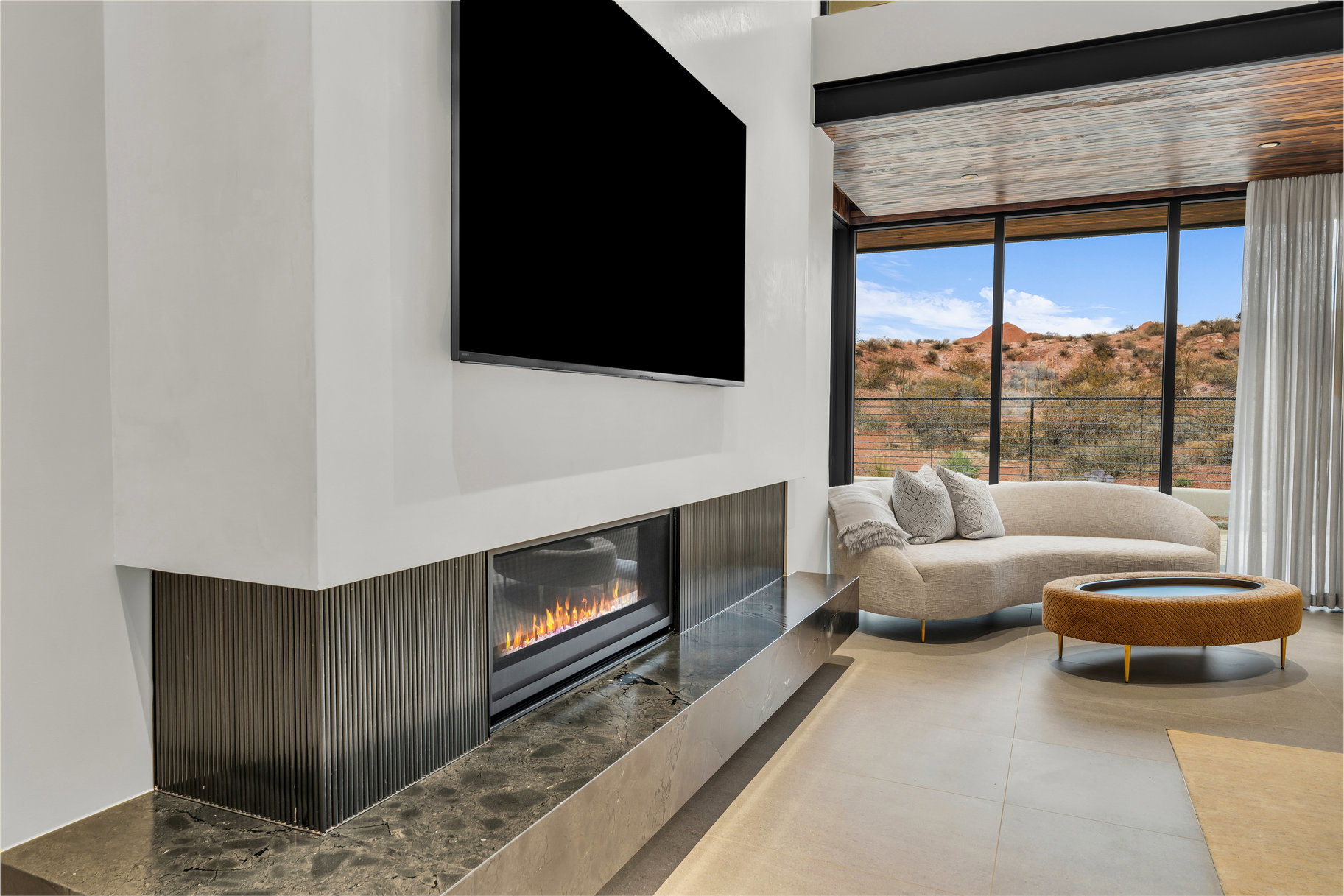 Living room featuring a glass covered fireplace and expansive windows