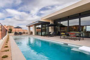 View of swimming pool with patio surround and outdoor dining space