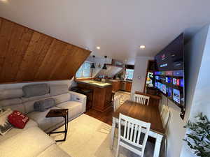 Living area with light wood-style floors and a vaulted wood ceiling