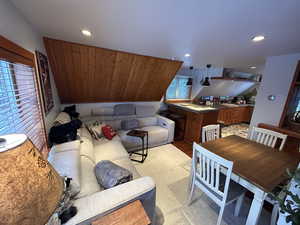 Living area featuring light wood-style flooring and vaulted ceiling
