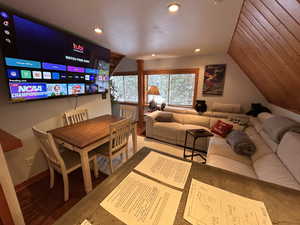 Living area featuring wood finished floors, lofted ceiling, and recessed lighting