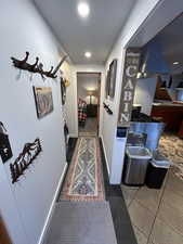 Corridor with dark tile patterned flooring and recessed lighting