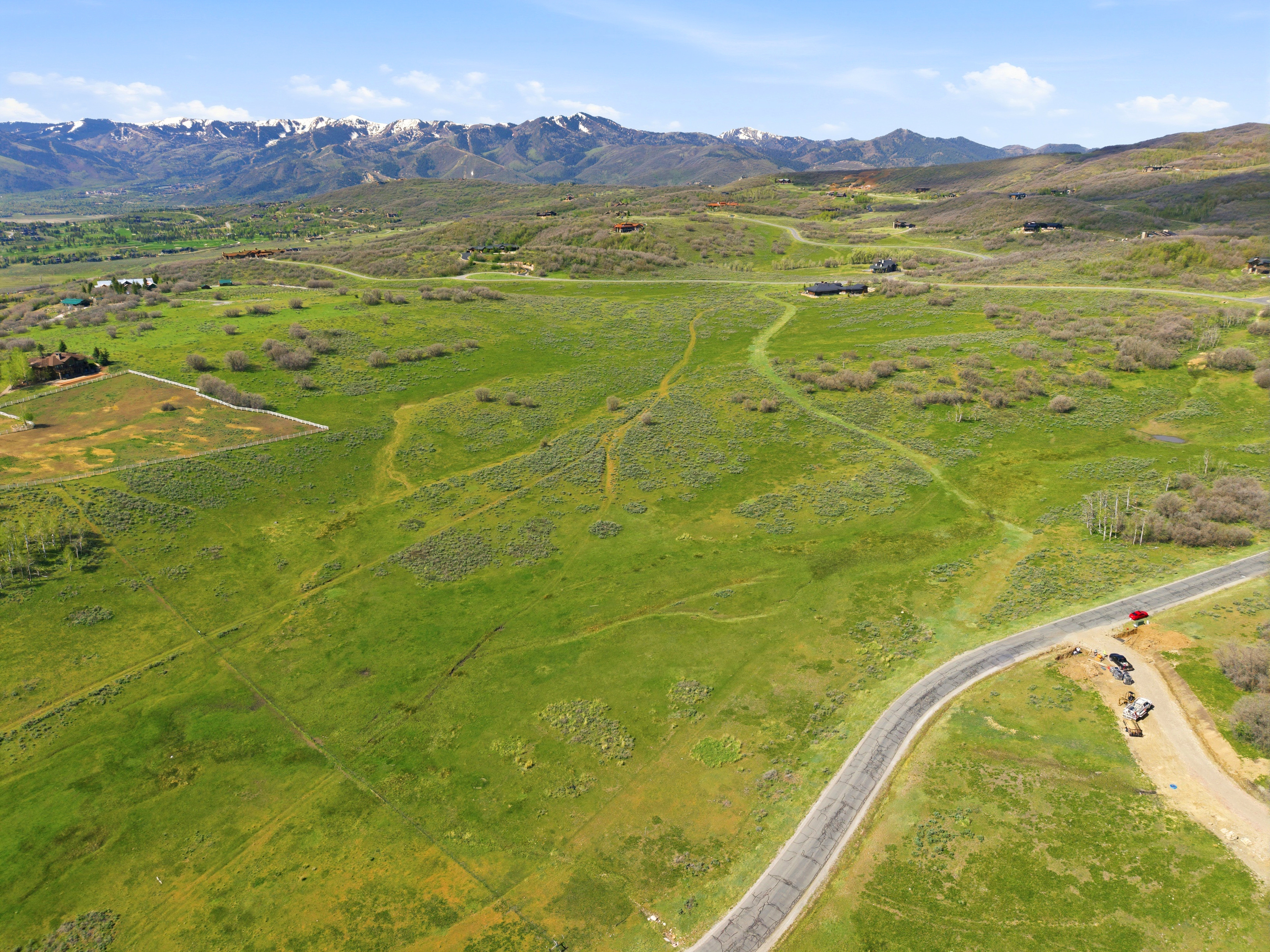Expansive green landscape featuring rolling hills and distant snow-capped mountains