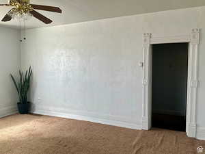 Spare room with ceiling fan and carpet floors