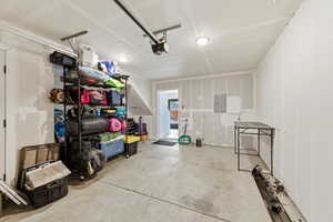 Garage featuring electric panel and a garage door opener