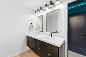 Full bathroom featuring double vanity and light wood finished floors