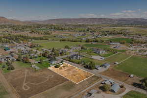 Aerial perspective of suburban area with a mountain backdrop and property parcel outlined
