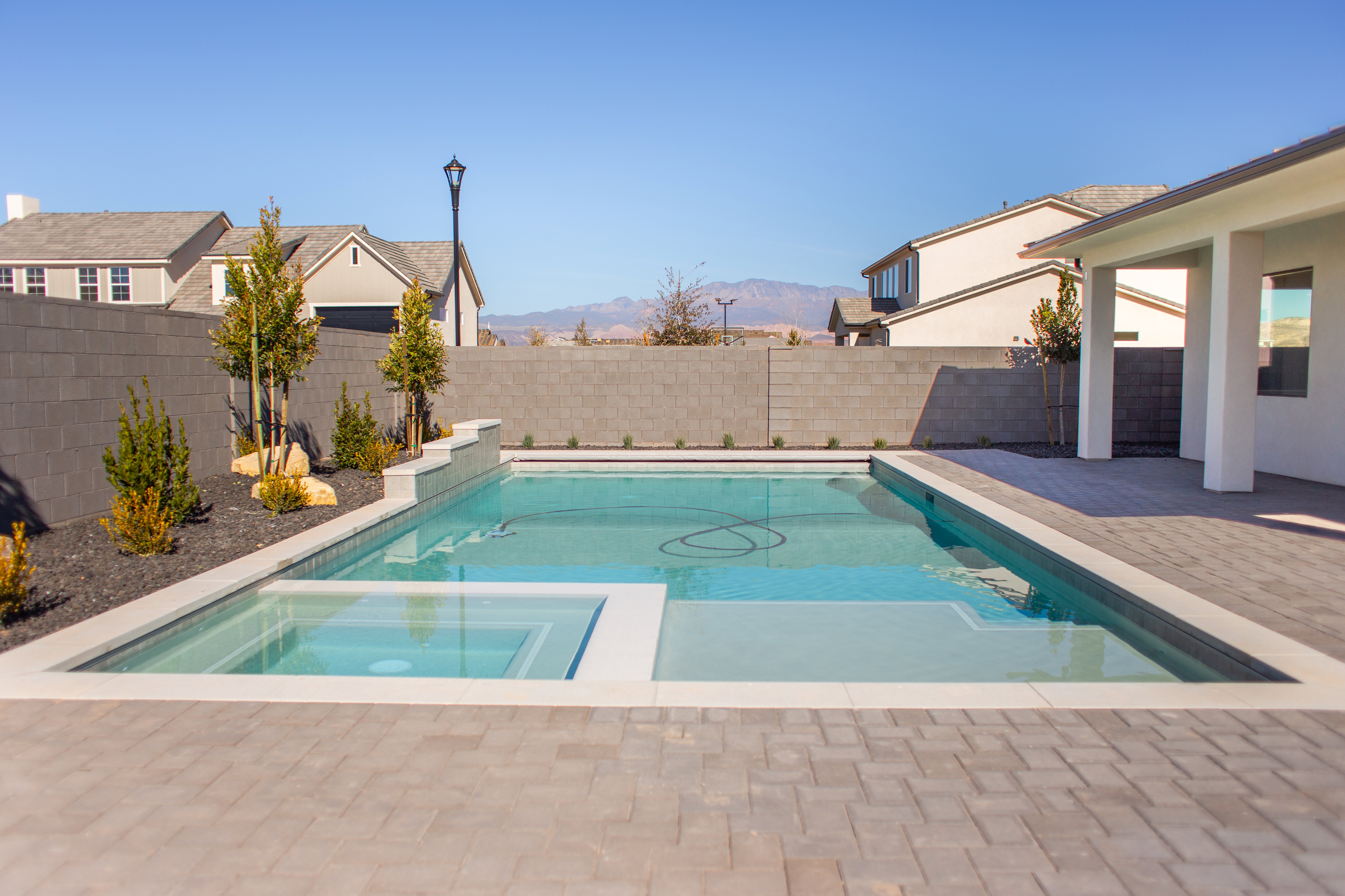 Integrated pool / hot tub featuring a fenced backyard, a patio area, and a mountain view
