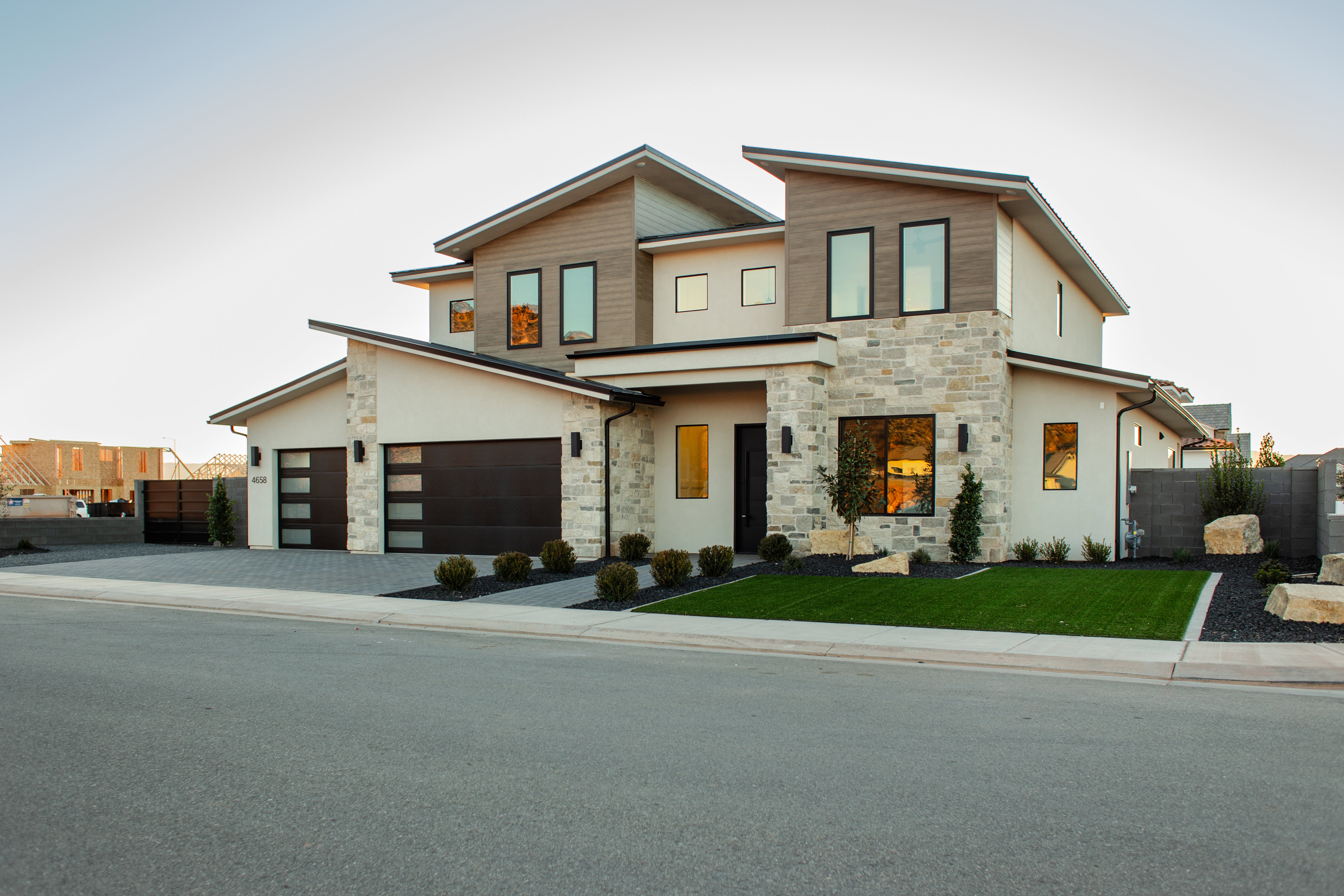 Contemporary home with stone siding, stucco siding, and driveway