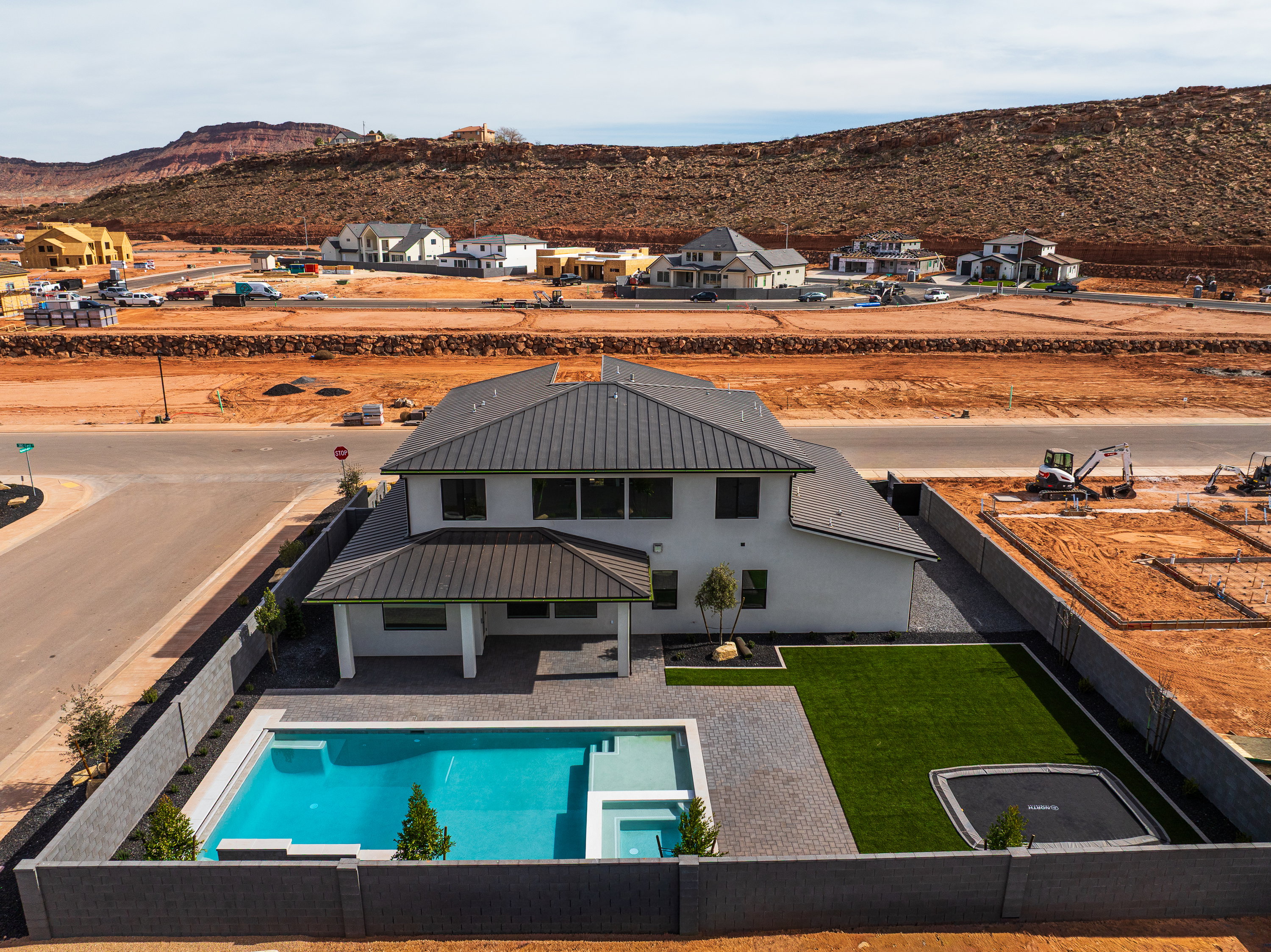 Back of house with a fenced backyard, a mountain view, a patio area, a metal roof, and a pool with connected hot tub