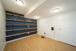 Finished basement with baseboards and light wood-style flooring