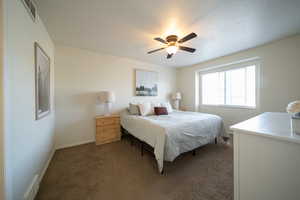 Carpeted bedroom with baseboards and ceiling fan