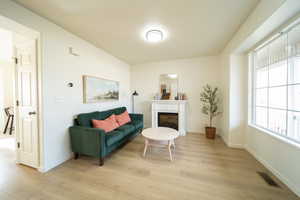 Sitting room featuring light wood-style flooring and a fireplace